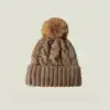 Bonnet Cache Oreille à Pompon, couleur beige, tricoté, motif torsade, bord côtelé.